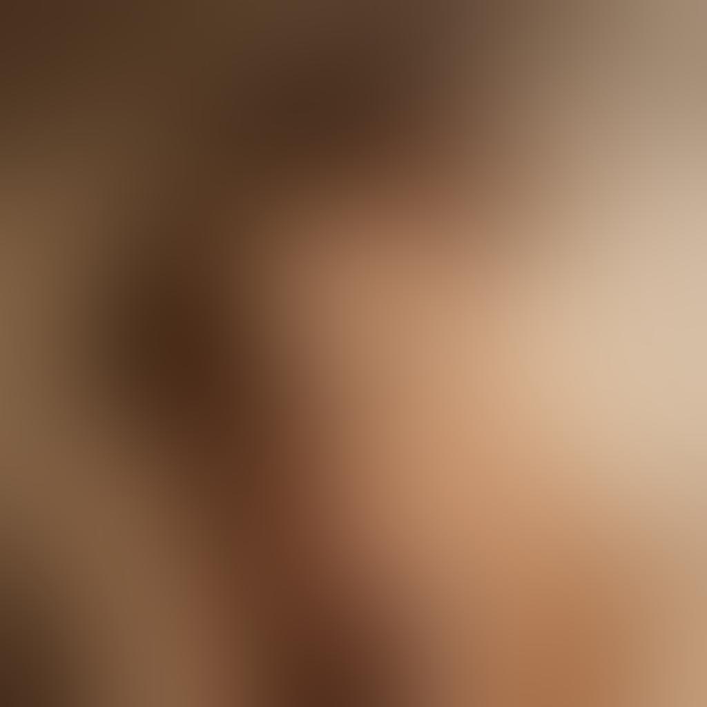 A striking nude photograph that beautifully displays the intricate play of light and shadow, accentuating the subject's skin tones and revealing natural curves. The backdrop is soft and blurred, enhancing intimacy without distraction; subtle expressions evoke raw emotion and vulnerability. Include elements of nature like delicate flowers or flowing fabric to symbolize connection and tenderness. super-realistic. warm tones. soft focus.